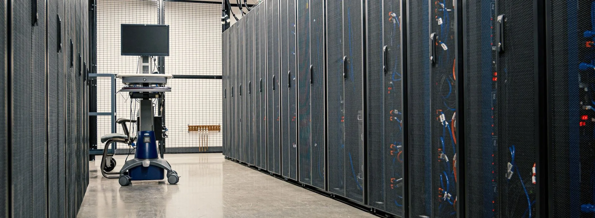 An aisle of server racks running the length of a data centre