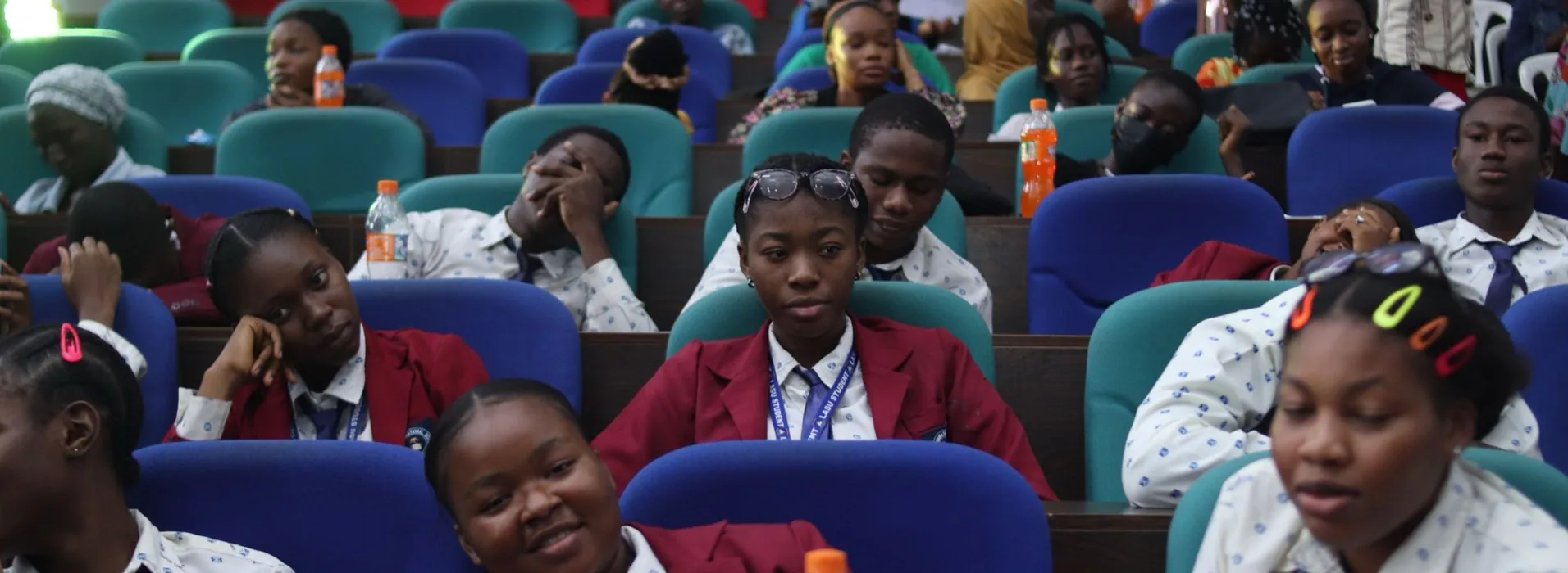 Students in blazers and uniforms filling the tiered seats of a lecture hall in Lagos
