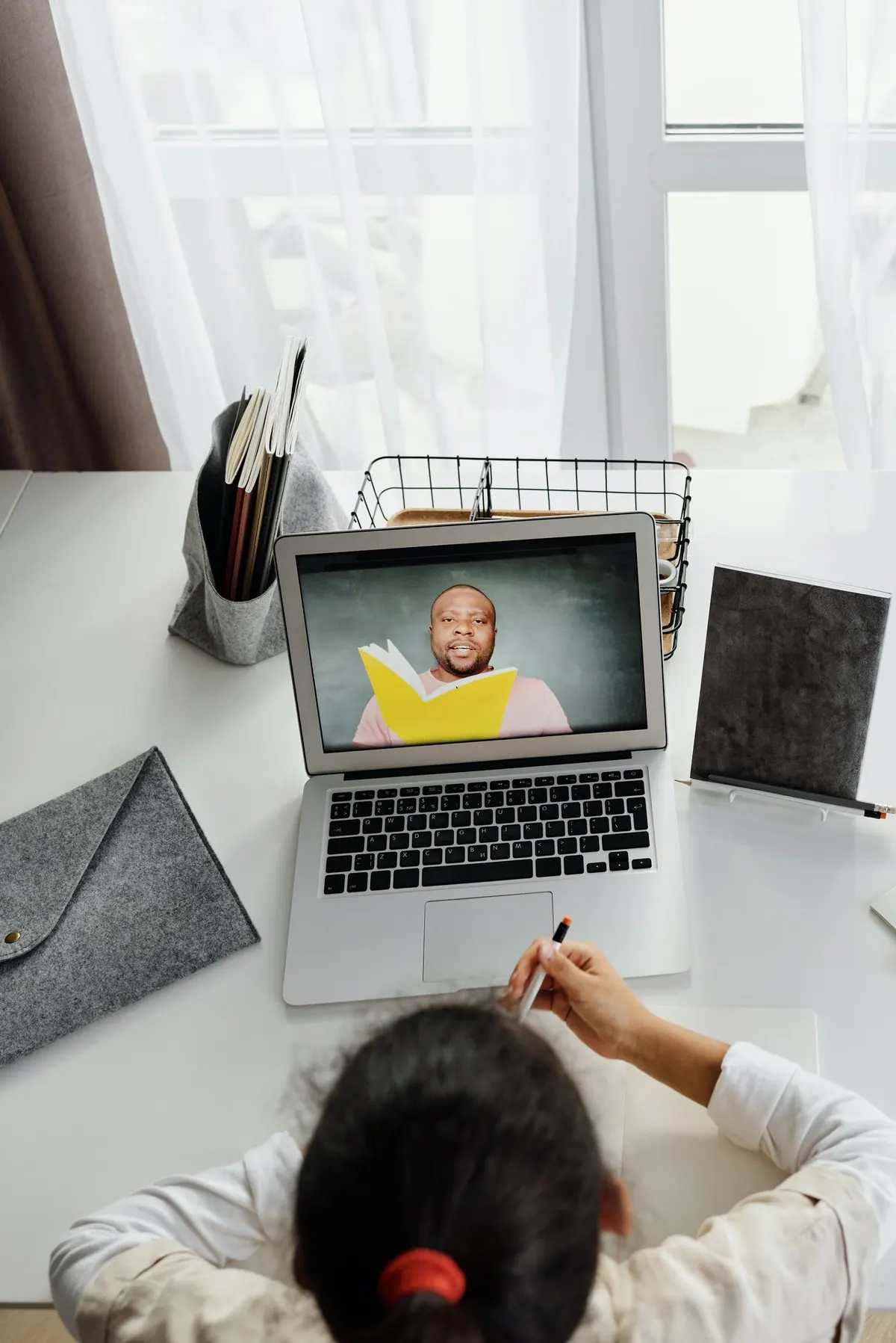 A child following a remote class on a laptop, the teacher on screen